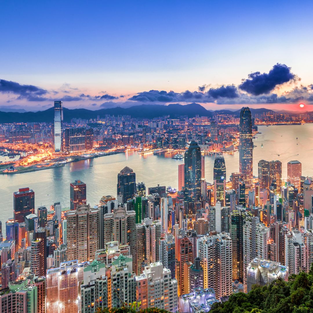 The skyline of Hong Kong and Victoria Harbour at dusk, with skyscrapers rising along the waterfront, a leading Asian financial centre and gateway to mainland China for private jet charter.